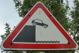 Street sign of a car going off a cliff